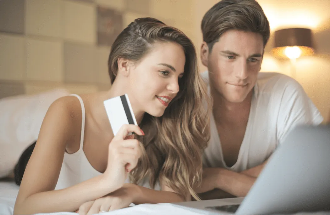 A couple booking and paying for a flight on a laptop with a credit card